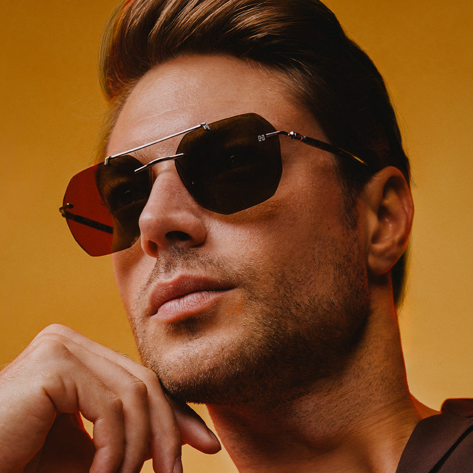 Man wearing sunglasses with a yellow background and 'HERMOSSA' branding.